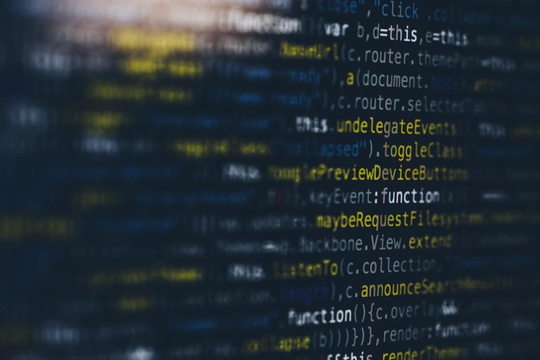 Blurry lines of colorful code on a dark background, partially legible with words like "function" and "render"