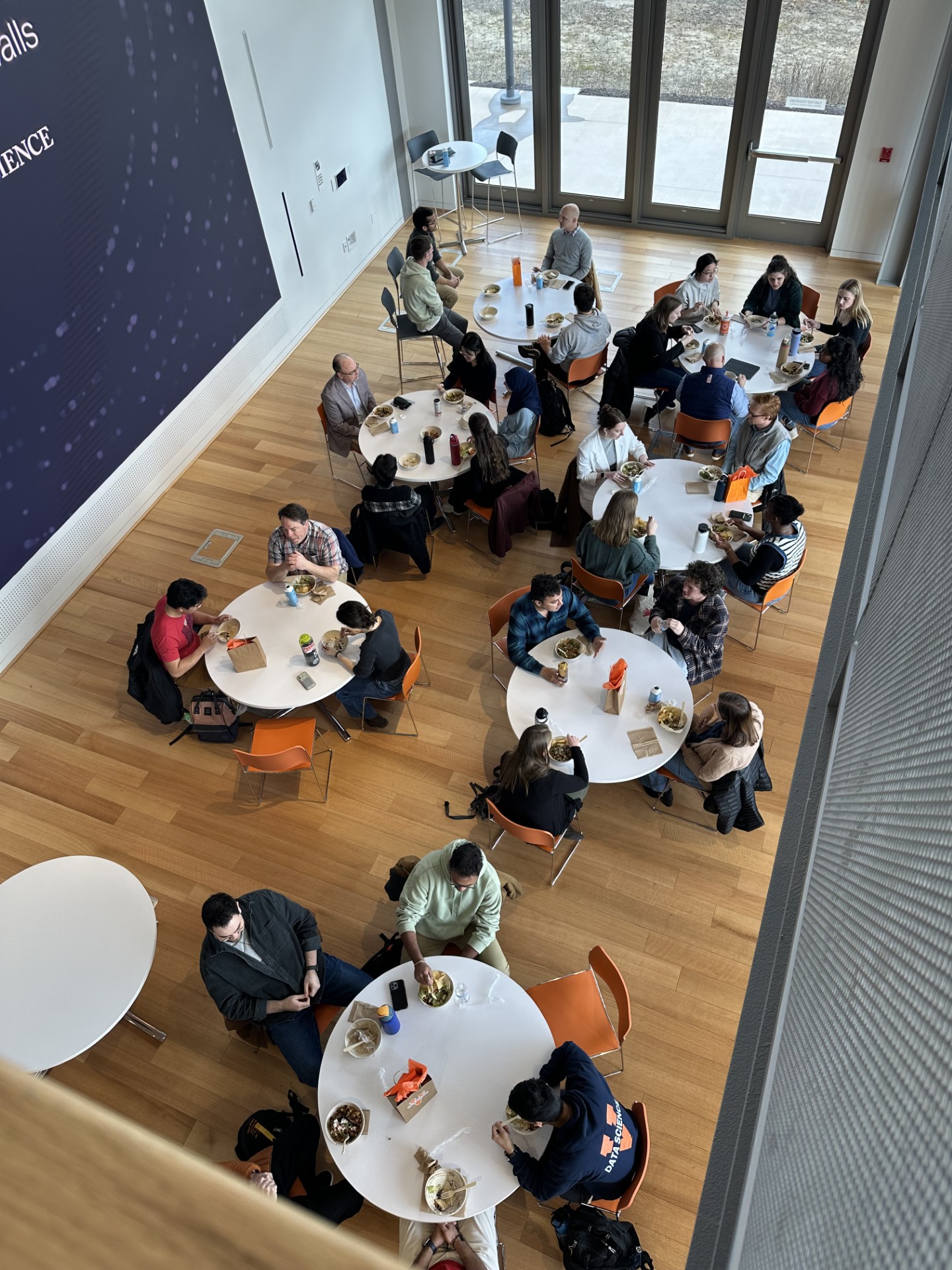 Overhead view of students and professionals participating in a roundtable lunch.