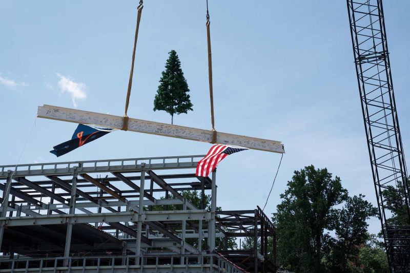 signed beam tops out new building