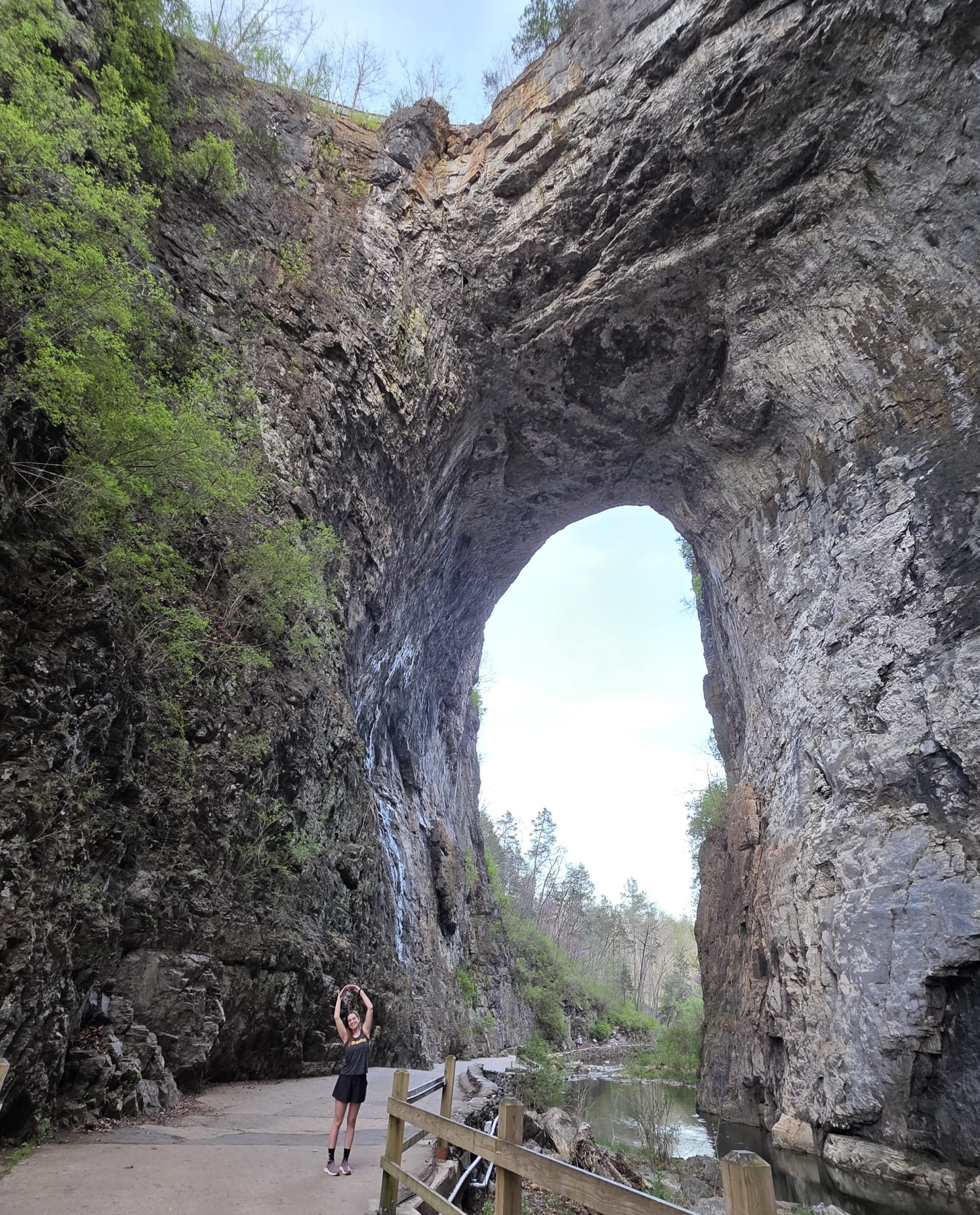 Caroline Kranefuss standing in front of a huge natural stone arch.