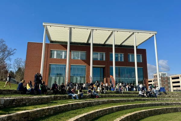 UVA Data Science building picture from the outside with students assembled in front